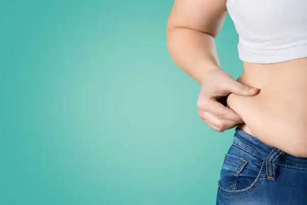 Image of woman pinching her love handles to show weight gain Sandy