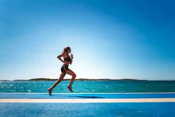 Woman running showing strong leg muscle Sandy